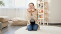 Happy smiling young woman calling her little baby boy learning walking on the carpet at living room. Baby development, making Royalty Free Stock Photo