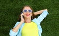 Happy smiling young woman calling on mobile phone while lying on grass in summer park Royalty Free Stock Photo