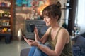 Happy smiling young woman drinking coffee at home in bed, using smartphone, reading news on social media or checking e-mails in Royalty Free Stock Photo