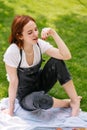 Happy smiling young woman eating cherry of the park lawn Royalty Free Stock Photo