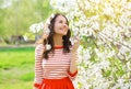 Happy smiling young woman in flowering spring garden