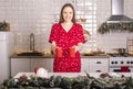 Happy smiling young woman holding or carrying two cups or mugs of tea at kitchen at christmas time Royalty Free Stock Photo