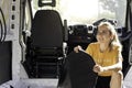 Happy smiling young woman holding rubber insulation for a camper van built convertion with copy space and backlight Royalty Free Stock Photo