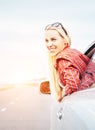 Happy smiling young woman looks out from car window Royalty Free Stock Photo