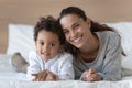 Happy smiling young woman lying on bed with son. Royalty Free Stock Photo