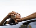Happy smiling young woman passenger drinking takeaway coffee and looking out car window. Concept of the enjoying car Royalty Free Stock Photo