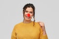 Happy smiling young woman with red clown nose Royalty Free Stock Photo