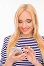Happy smiling young woman typing sms on mobile phone Royalty Free Stock Photo