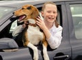Happy smilling girl and beagle puppy sitting in car Royalty Free Stock Photo