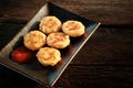 Happy snack with Chicken nugget with smile tomato sauce in black plate on rough wooden Royalty Free Stock Photo