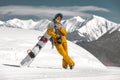 Happy snowboarder stands with snowboard at ski slope Royalty Free Stock Photo