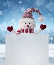 Happy snowman behind the blank advertising banner with copy space Royalty Free Stock Photo