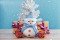 Happy snowman standing in blue winter christmas snow background. Royalty Free Stock Photo