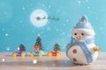 Happy snowman standing in blue winter christmas snow background. Merry christmas and happy new year greeting card with copy-space. Royalty Free Stock Photo