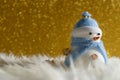 Happy snowman standing in gold winter christmas snow background. Merry christmas and happy new year greeting card with copy-space. Royalty Free Stock Photo