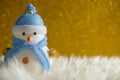 Happy snowman standing in gold winter christmas snow background. Merry christmas and happy new year greeting card with copy-space. Royalty Free Stock Photo