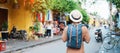 Happy Solo traveler sightseeing at Hoi An ancient town in central Vietnam, man traveling with backpack and hat. landmark and