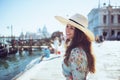 Happy solo traveller woman in floral dress enjoying promenade