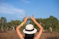 Happy solo traveller woman showing two fingers and looking beautiful view at forest,Back view