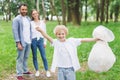 Happy son holding garbage bag near parents