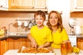 Happy son and mother slicing pizza in the kitchen Royalty Free Stock Photo