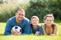 Happy son and parents lying in football field Royalty Free Stock Photo