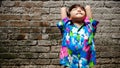 Happy Southeast Asian ethnicity little boy having fun sunbathing in the morning at home backyard