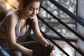 Happy sport asian woman taking a rest during exercising in gym by sitting on steps and holding bottle of water Beautiful young gir Royalty Free Stock Photo