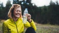 Happy sport girl laughing quenches thirst after fitness. Smile person drinking water from plastic bottles relax after exercising