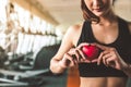 Happy sport woman holding red heart in fitness gym club. Medical cadio heart strength training lifestyle. Pretty female sport girl