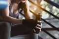 Happy sport woman taking a rest during workout in gym by sitting on steps and holding bottle of protein shake Beautiful young girl Royalty Free Stock Photo