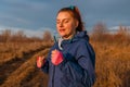 Happy sportive woman listening to music on headphones while jogging in nature in the morning. Healthy lifestyle concept Royalty Free Stock Photo