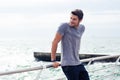 Happy sports man resting near sea outdoors