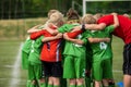 Happy sports team with a young coach. Children playing a football game on stadium pitch Royalty Free Stock Photo