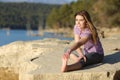 Happy sportswoman stretching leg in nature