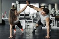 Happy sporty couple giving high five to each other while doing push up together in gym. Unity and support, copy space Royalty Free Stock Photo