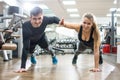 Happy sporty couple giving high five to each other while doing push ups together in the gym Royalty Free Stock Photo