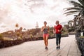 Happy sporty couple running outdoor - Fit friends jogging and training together outside Royalty Free Stock Photo