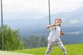 Happy sporty primary school age child, girl playing badminton outdoors action shot, copy space, one person. Children and sports