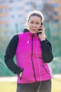 Happy sporty woman with smartphone. Female athlete using smartphone during workout rest