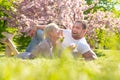 Happy spring couple in love having fun. Beautiful smiling young lovers enjoying flowering garden. Royalty Free Stock Photo