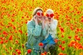 Happy spring family. Mother and daughter hugging in a poppies meadow. Mom and child girl resting in the field with poppy Royalty Free Stock Photo