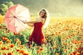 Happy spring woman in retro hat in field of poppy. Pin up woman style. Sexy girl with pink umbrella and red dress in Royalty Free Stock Photo