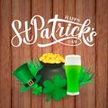 Happy St. Patrick s day calligraphy hand lettering, Leprechaun s hat, clover, glass of green beer and pot of golden coins on wood Royalty Free Stock Photo