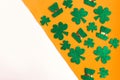 Happy St. PatrickÃ¢â¬â¢s Day. Green hat and shamrock pattern on white and orange background.