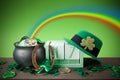 Happy St. Patrick's day. Shiny shamrocks, gold coins and leprechaun hat on a wooden background with rainbow Royalty Free Stock Photo