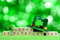 Happy St Patricks Day blocks, leprechaun hat over twinkling green Royalty Free Stock Photo