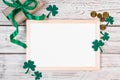 Happy St. Patricks Day concept. Clover shamrock, gold coins and a gift with a green ribbon on a white background. Festive