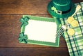 Happy St. Patricks Day Menu or Invite Card with Shamrocks, Hat, Lucky Coins, Napkins and fork from top down view with blank area