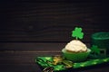 Happy St. Patricks Day Still Life with a Cupcake, Shamrocks, Hat, and Gold Coins for Good Luck and Celebration.  It`s a horizonta Royalty Free Stock Photo